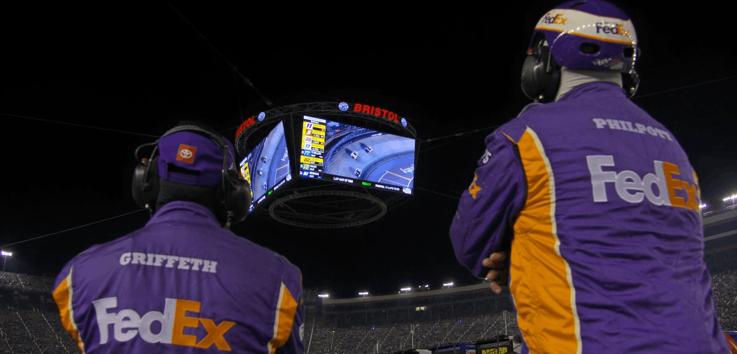 Bristol Motor Speedway suspended LED scoreboard showing live race footage and data at night